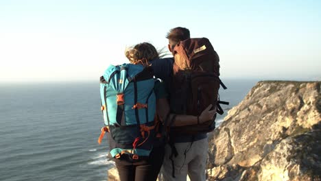 romantic couple of tourists standing at cliff