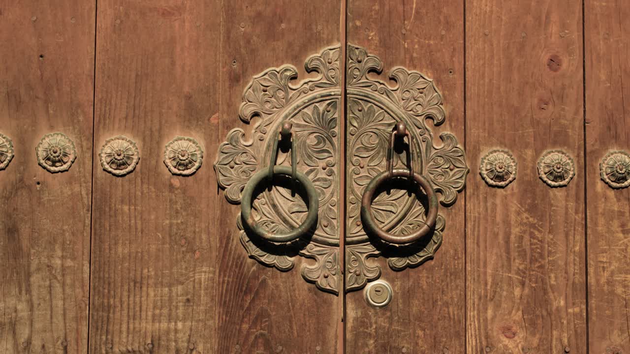 Close-up of Korean Hanok door with traditional ornate metal hardware and natural wood grain, emphasizing the artistry and historical character of the building element