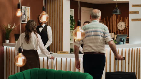 senior couple arrive in hotel lobby