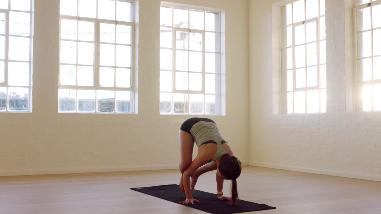 gesunde yoga-frau praktiziert krähenpose und genießt den fitness-lebensstil beim training im trainingsstudio, stretching-training auf der trainingsmatte bei sonnenaufgang