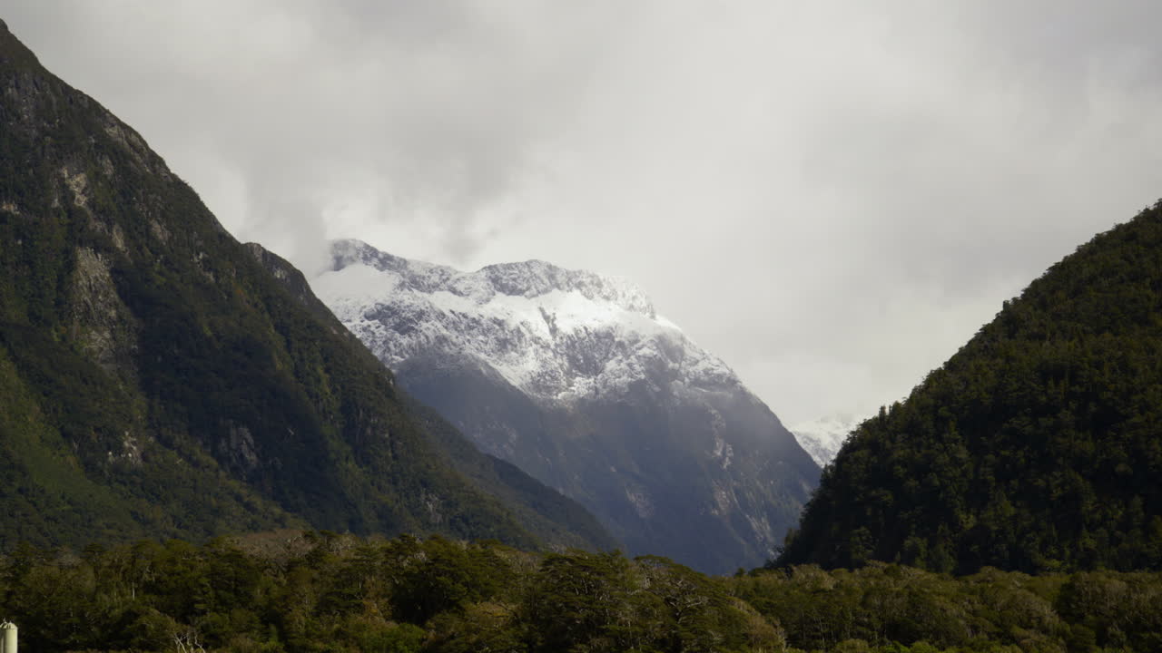 la nieve de lapso de tiempo se asienta en el punto de la mosca de la arena mientras las sombras de las nubes se mueven a través de la montaña