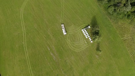 Tractor-stacking-up-hay-rolls-in-a-Field