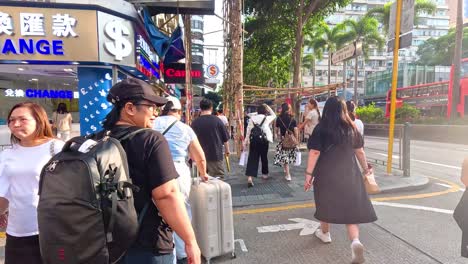 people walking with luggage on a city street