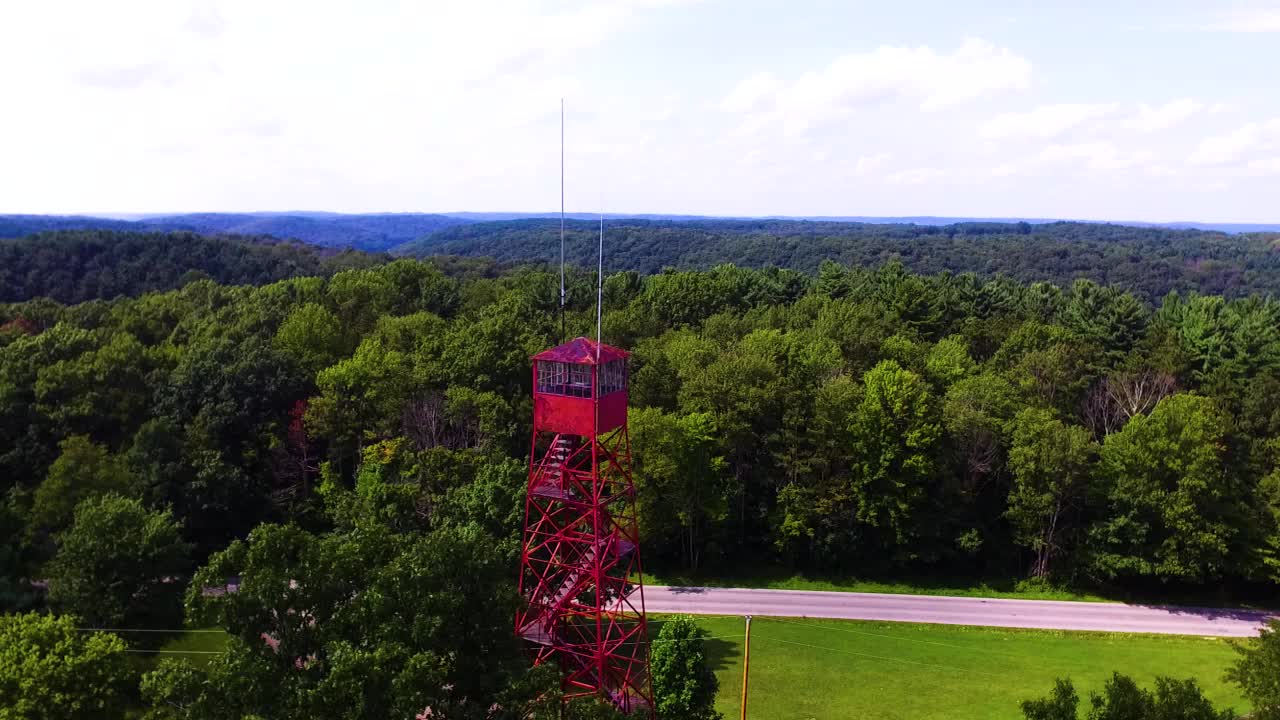 Aerial View of a Red Fire Tower in a Lush Green Forest