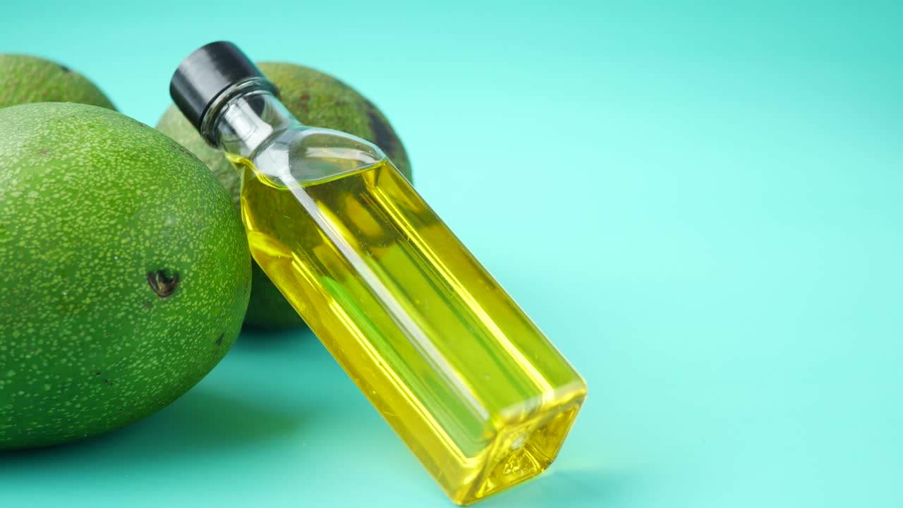 botella de aceite de aguacate con aguacates frescos