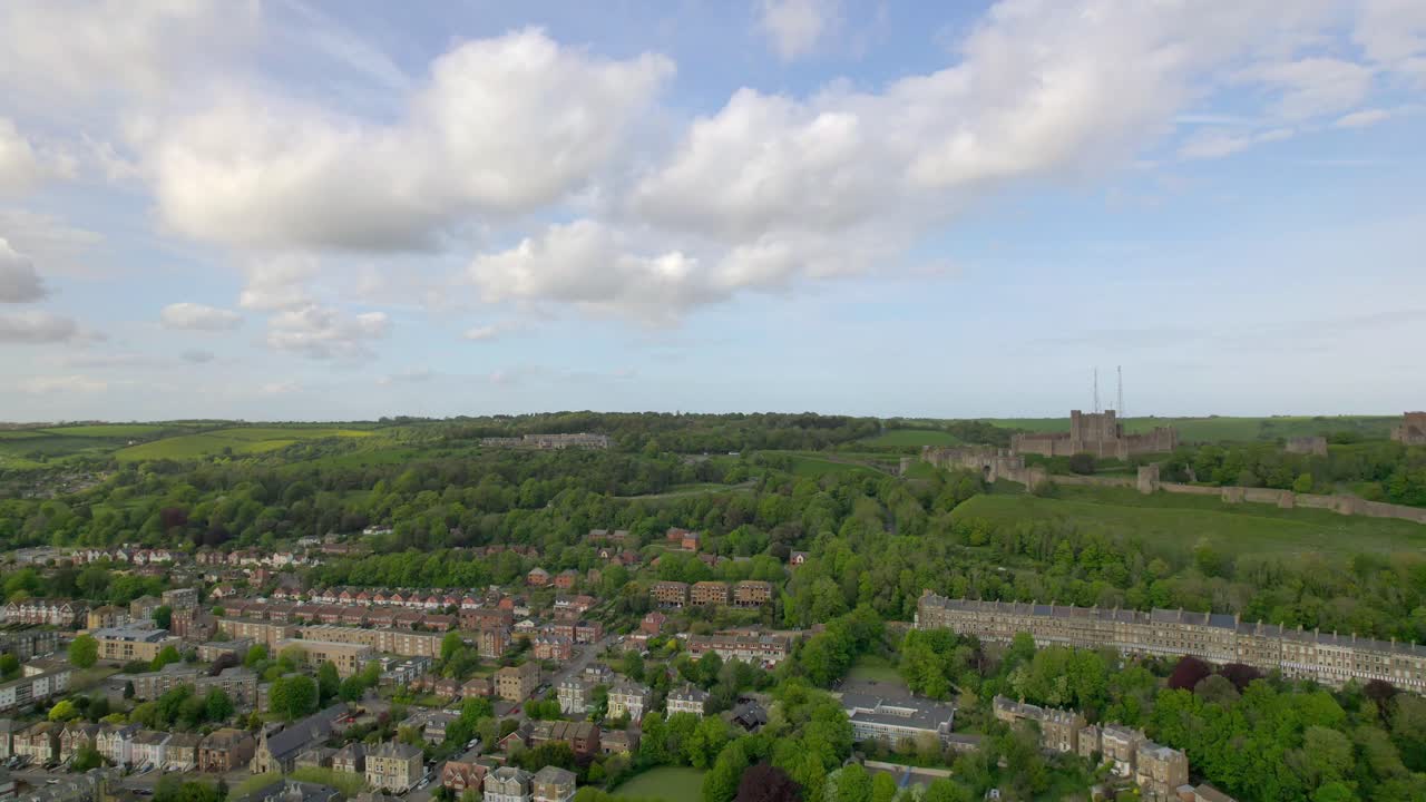 дронные кадры доверского замка и окружающего города, демонстрирующие историческую архитектуру и зеленые холмы