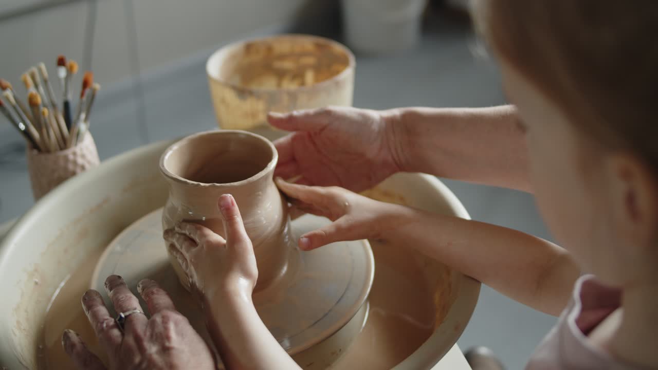 할머니는 손녀에게 도자기 회전 바에서 일하는 법을 가르니다.
