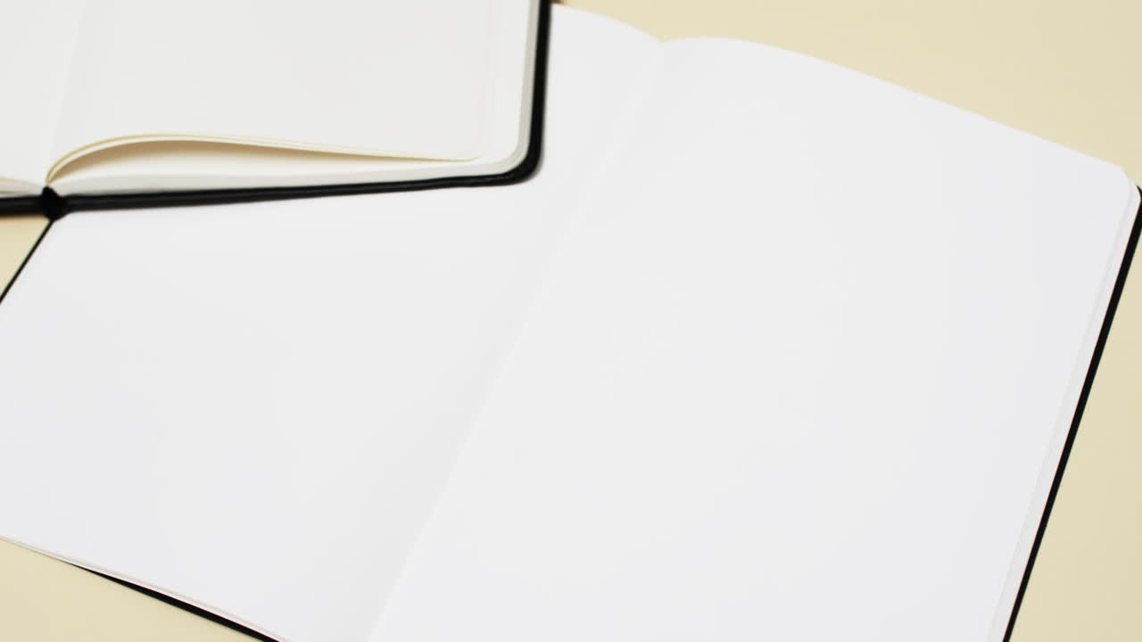 Video of books with white blank pages and copy space on yellow background