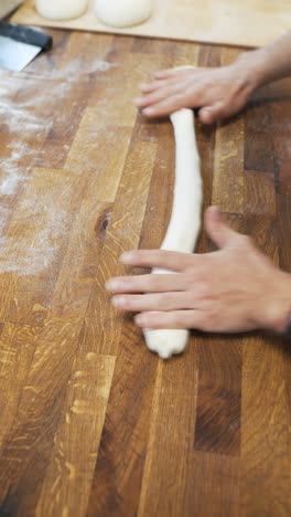panadero haciendo masa en la encimera de madera