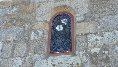 stained glass window in stone wall with white flowers