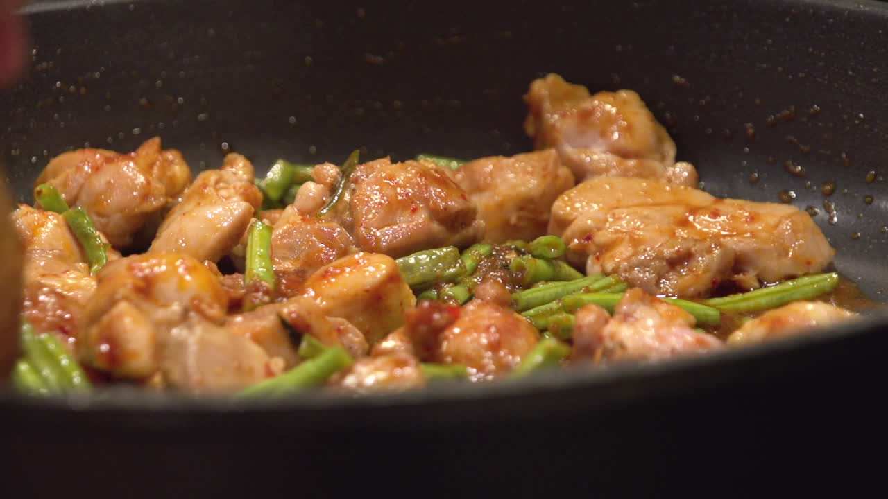 Cooking Thai food, Gai Pad Prick Gaeng, in a hot frying pan.