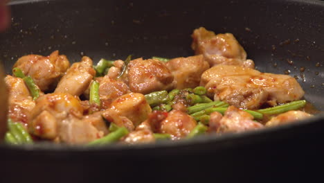 cooking thai food, gai pad prick gaeng, in a hot frying pan.