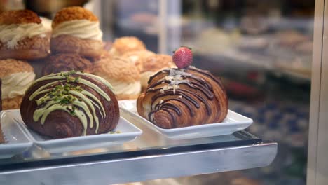 a display of delicious pastries, including a croissant with chocolate and pistachio, a croissant with chocolate and a strawberry, and a selection of other pastries