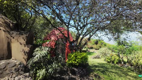 pan right of dome-shaped superadobe structures, eco-friendly, flood and earthquake-resistant, surrounded by trees and plants