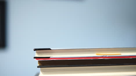 close up book on stack inside room on table - tilt camera