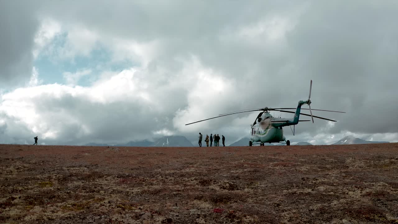 un helicóptero aterrizando en una tundra montañosa