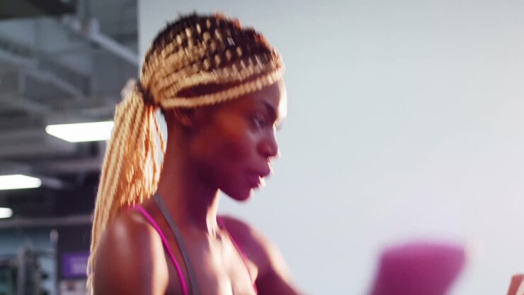 Fit woman exercising on cross trainer