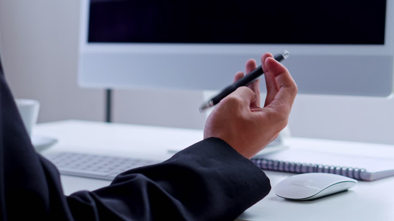 Side view of professional in suit spinning pen while thinking at minimalist workstation