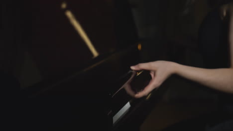 persona tocando el piano en una habitación oscura