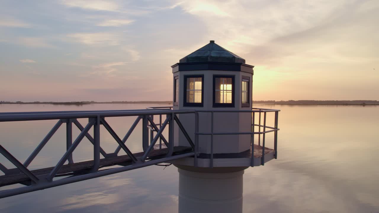 해가 뜨는 동안 friesland의 oostmahorn 등대 뒤에 태양이 나타납니다.