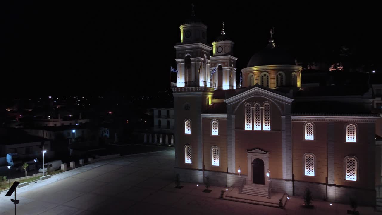 Aerial night view of Ypapanti christian orthodox church, located at historical center of Kalamata. Establishing, orbital drone movement 4k