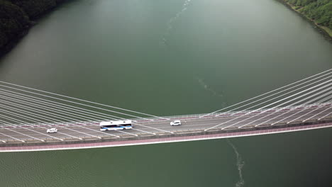 overhead vortex aerial of large bridge over green water