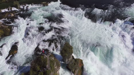 Tracking-shot-of-a-rock-sitting-in-the-roaring-waterfall-Rheinfall-at-Schaffhausen-in-Switzerland