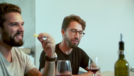 two smiling handsome guys talking during dinner