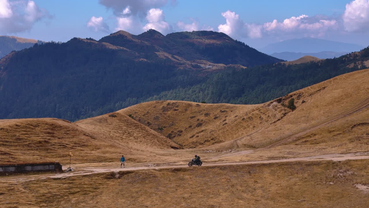 Ripresa con drone di un uomo in moto in Nepal, Pikey Peak, regione collinare, avventura 4K.