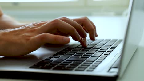 close up of hands typing with a laptop