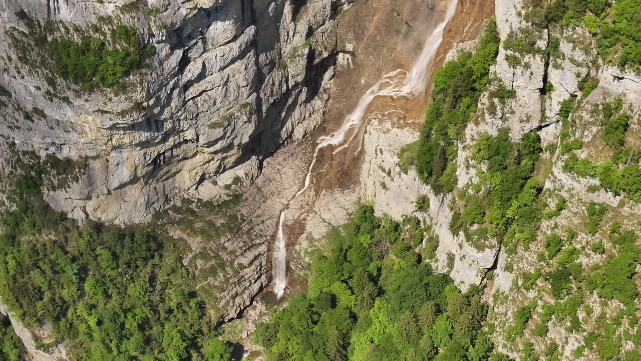 narrow waterfall winds along rugged cliff wall at seerenbachfälle switzerland