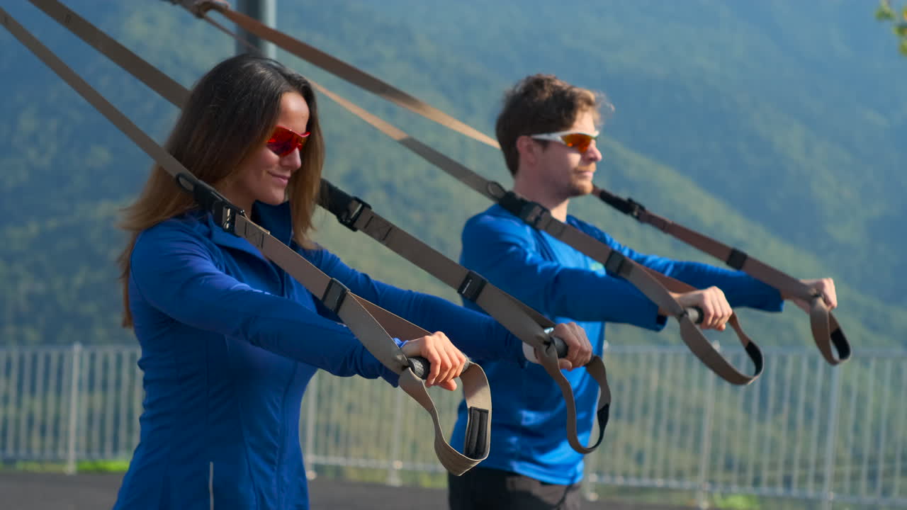 부부가 서스펜션 트레이닝으로 운동하고 있습니다.