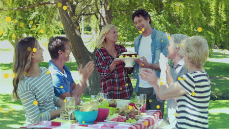 animation of spots over happy caucasian family having dinner