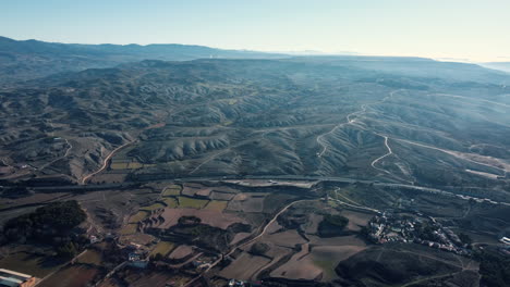 aerial view of a mountainous rural landscape with roads and fields