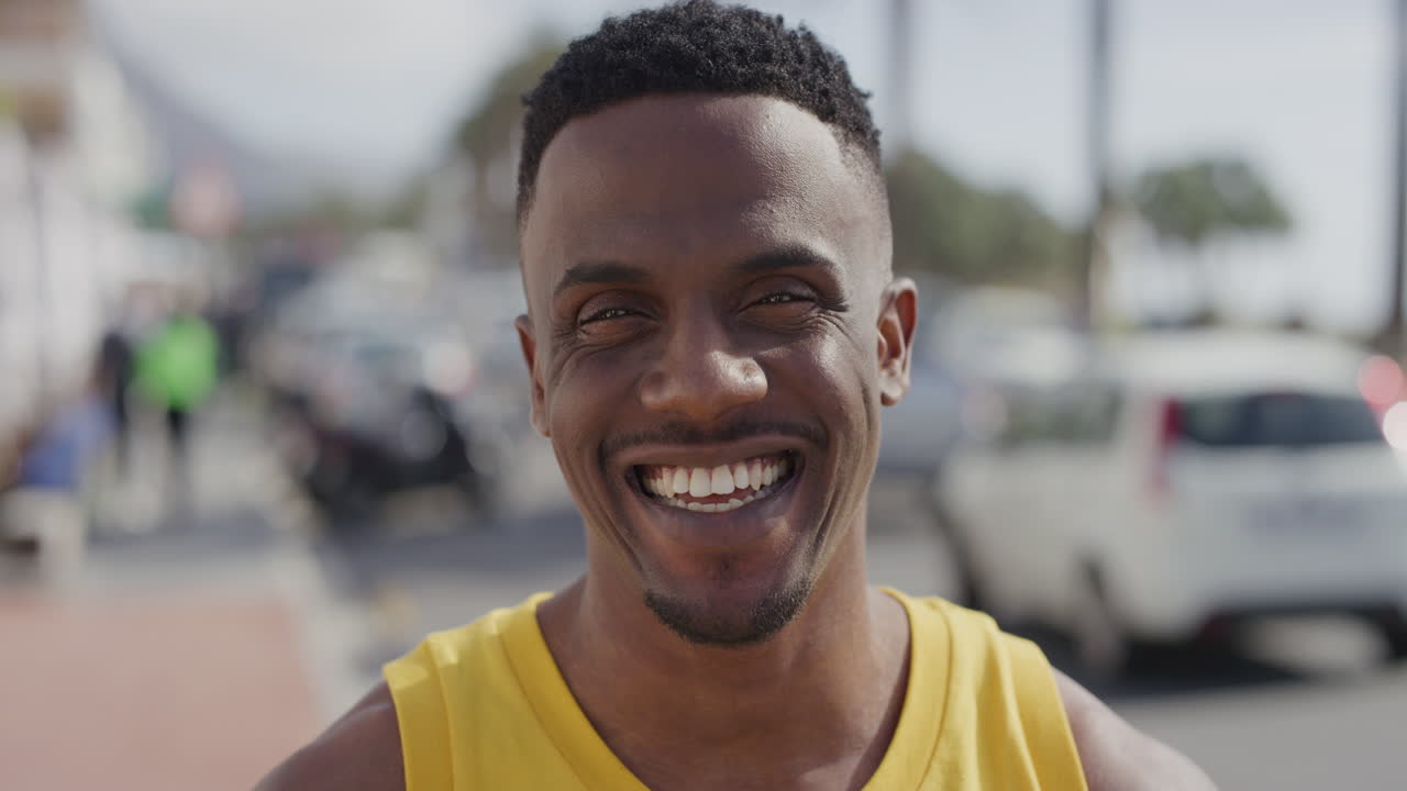 portrait of attractive african american man smiling cheerful looking at camera enjoying summer vacation in urban city waterfront handsome black male happy satisfaction