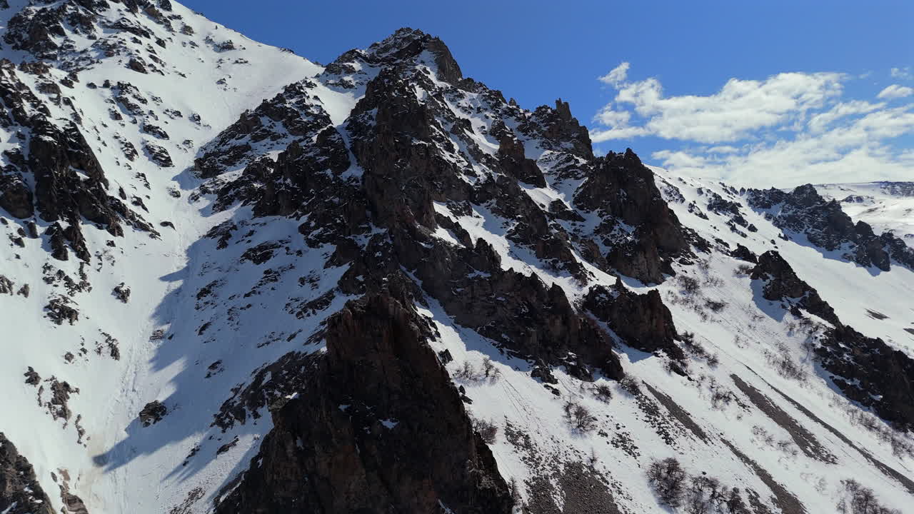 아르헨티나의 세로 라 호야 스키 리조트에서 눈 인 산꼭대기와 휘어지는 경로를 한눈에 볼 수 있습니다.