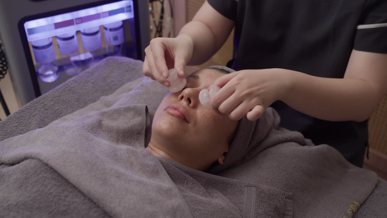 Young Girl Having Rose Quartz Massage on Face at Beauty Salon