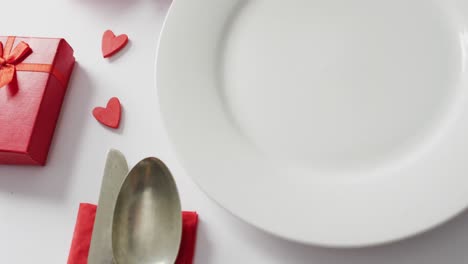 Roses-and-plate-with-cutlery-on-white-background-at-valentine's-day