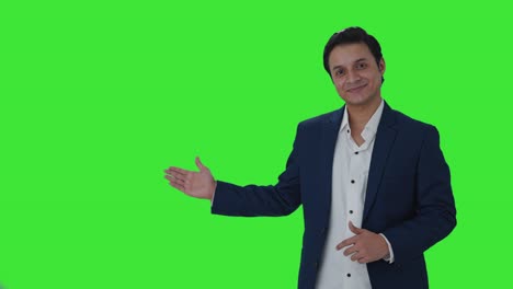 Feliz-Periodista-Indio-Señalando-El-Espacio-De-Copia-Y-Mostrando-Los-Pulgares-Hacia-Arriba-En-La-Pantalla-Verde