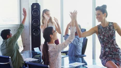 ejecutivos de negocios dando un alto cinco en la oficina 4k