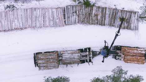 Carga-De-Troncos-Desde-Terrenos-Nevados-En-Camiones-Utilizando-Un-Cargador-De-Garras.