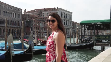 attractive woman in red printed dress smiling at camera in venice, italy