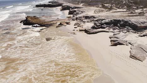 antena: algas rojas en el agua en la playa sudafricana junto a la ruta del jardín