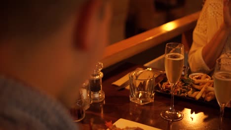 young man in a shirt shot from behind eating new zealand crayfish in a luxury restaurant with his wife - close up