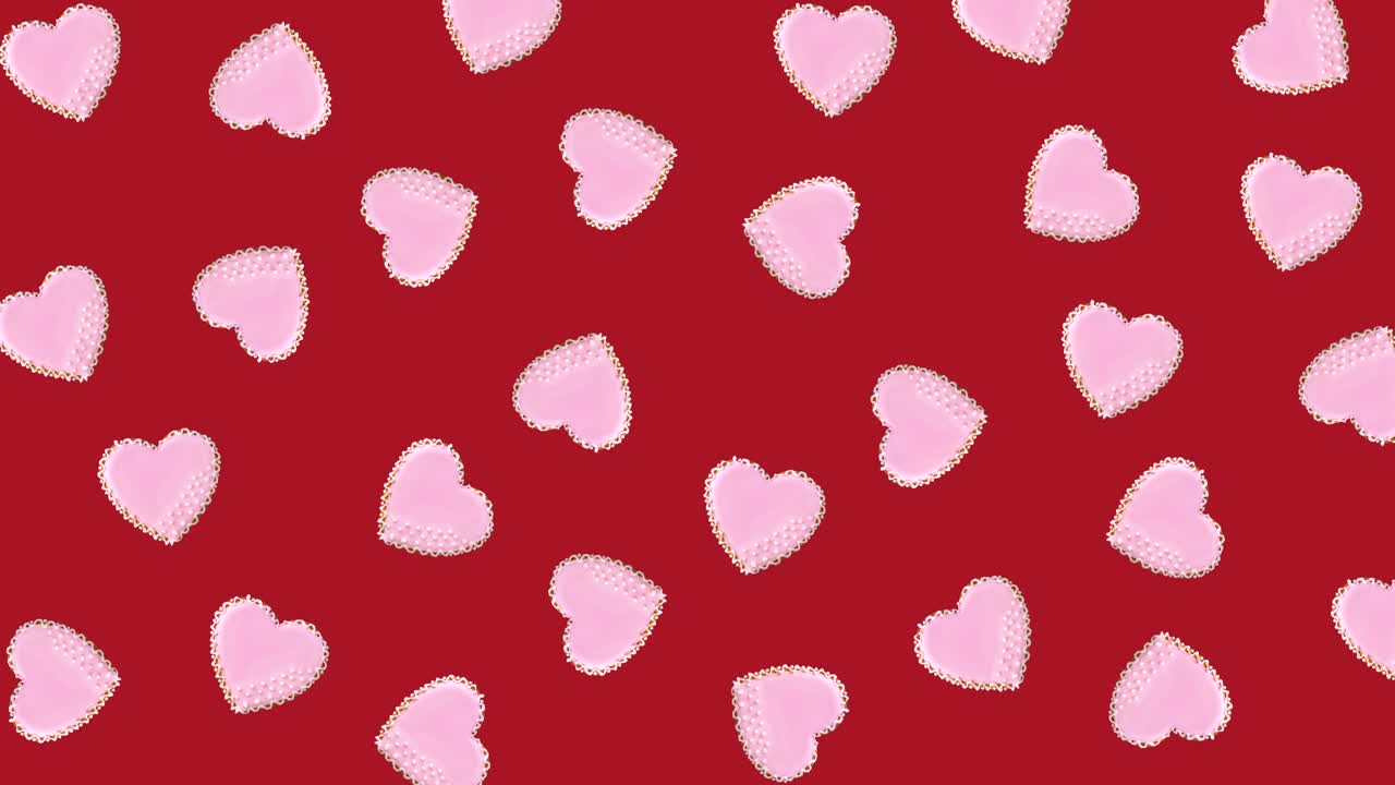 heart shaped cookies decorated with white glaze wiggle on a red background