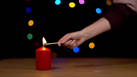 encendiendo una vela de navidad con fondo bokeh