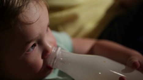 el niño bebe yogur de una botella