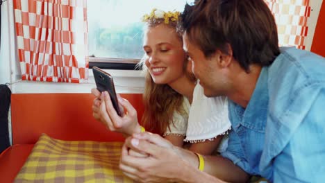 woman using mobile phone while talking to man in camper van 4k