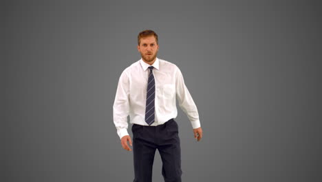 businessman walking towards camera and shouting angrily on grey background