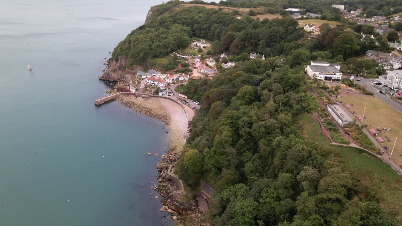 vista aérea descendente del hermoso paisaje oceánico con costa rocosa, acantilados, árboles y edificios